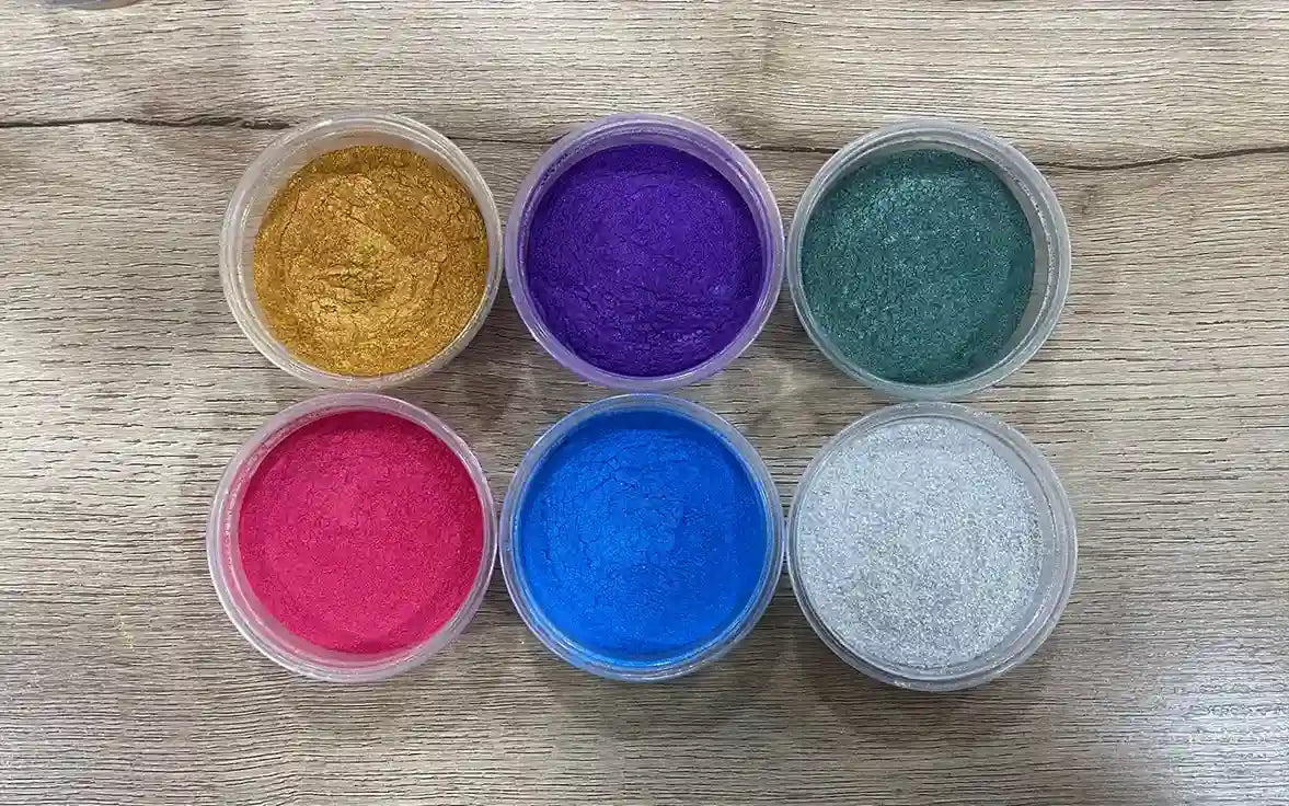 Cosmetic-Grade Mica Powder, six open tubs of gold, purple, teal, pink, blue and white powder